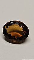 Oval cut Madeira citrine gemstone, displaying deep cognac color and faceted surface