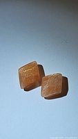Pair of natural peach moonstones viewed from above on white background showing their fancy cut and internal shimmer.