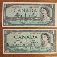 Front view of two 1954 Canadian one dollar replacement notes showing Queen Elizabeth II, denominational text, bank name, serial numbers, and signatures.