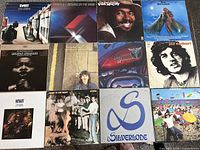 Top view of 12 vinyl LP record covers including Sweet, George Harrison, Joe Cocker, Doc Holliday, Spirit, Utopia and Silverlode.
