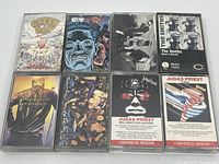 Top view of 8 cassette tapes in their cases showing cover art from bands Green Day, Iggy Pop, Beastie Boys, The Smiths, Judas Priest (2), and The Tragically Hip (2).