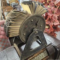 Side view of the antique metal rotating card wheel loaded with aged index cards.
