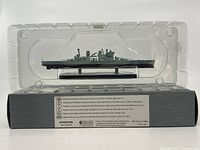 Front view of HMS Prince of Wales model in clear plastic clamshell displaying the ship details and base stand with name plaque.