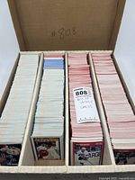 Full box of hockey cards neatly organized in rows separated by dividers, showing large quantity in multiple color-striped backs indicating various card sets inside the lot.