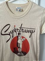 Front close-up of beige Supertramp tour T-shirt with waitress graphic and Supertramp text.