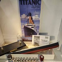 Photo shows the long ship hull of the Titanic model unassembled along with paint bottles and assembly instructions in the background.