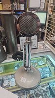 Full view of vintage chrome Astatic D104 microphone mounted on T-UG8 weighted base stand with some surface tarnish.