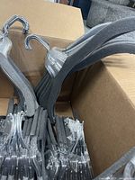 Box containing 50 black velvet padded clothes hangers with chrome hooks