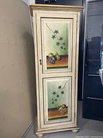 Front view of closed cabinet door showing two painted panels