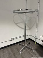 Full view of the round metal clothing rack showing circular top frame and central pole.