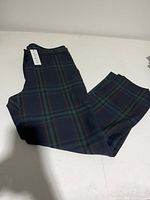 Dark plaid pants folded on white surface