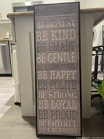 Photo of a rectangular wooden decorative sign displaying family rules text.