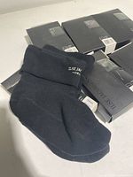 One black Ilse Jacobsen boot sock unfolded showing the logo and material detail.