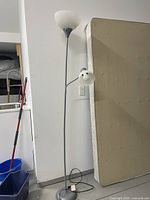 Full height view of the 6ft floor lamp showing the slim metallic pole, circular base, top frosted glass globe, and adjustable smaller reading lamp on the side.