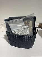 Basket containing three letter boards and multiple plastic bags of white plastic letters and accessories.