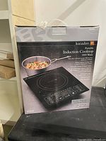 Front view of Kuraidori Portable Induction Cooktop box showing product image and features.