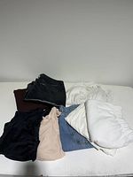 All clothing items laid flat on white surface showing various colors and shapes.