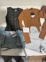Close-up of selected tops, shorts, skirts laid flat with visible tags and labels.