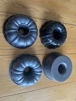Top view of 4 different shaped bundt pans arranged on wooden floor