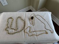 All four necklaces laid out on white fabric