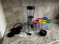Full set of Magic Bullet blender with all jars, lids, blade attachments, and base on kitchen countertop.