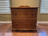 Front view of wooden credenza showing two large drawers with round knobs and center keyholes.