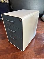 Side view of the blue and white 3-drawer filing cabinet showing shape and design.