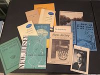 Top-down photo of ten assorted vintage and historic ephemera documents and publications related to New Jersey history, parks, and Trenton including booklets, brochures, and magazines in various colors.