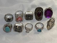 All ten rings on white fabric, two rows of five