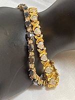 Photo showing two bracelets worn on wrist, sapphire and diamond styles.