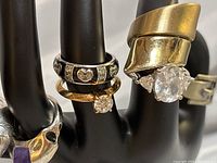 Photo showing all rings on black display hand highlighting the gemstone and heart designed bands.