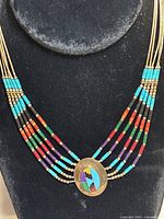 Front view of entire necklace displayed on black velvet bust