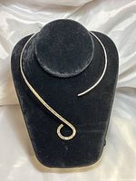 Front view of the hammered sterling silver collar necklace displayed on black velvet bust, showcasing the smooth end and stamped circular loop end.
