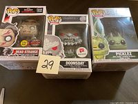 Three boxed Funko POP! collectible figurines: Dead Strange, Doomsday, and Picklez.