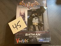 Front view of the Batman Arkham Asylum vinyl figure in original box with seller's lot number card 45.