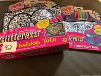 Photo of Glitterazzi large Fashion Tote boxed set with 5 permanent markers and small Wristlet Bag set with 4 permanent markers, with color-your-own fabric designs.