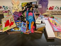 Full overview of miscellaneous lot items including toys, pens, socks, cleaning supplies, and packaging