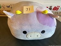 Front view of the light purple and cream Squishmallows plush toy showing yellow horns and embroidered eyes and snout.