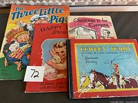 Four vintage children's storybooks arranged side by side showing colorful illustrated covers and signs of wear.