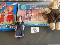 Vintage toys and dolls including boxed Annie doll, Early American Playset, small vintage doll, and teddy bear doll.