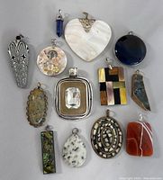 Overview of all 13 vintage pendants arranged in a group showing size, shapes and materials.
