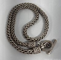 Coiled 18 inch necklace with toggle clasp showing overall chain design and end caps with swirl motifs.