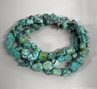 Close-up of coiled turquoise nugget 3-strand bracelet showing natural stones and shapes.