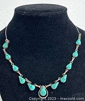 Front view of the necklace on black bust display showing turquoise stones and silver settings