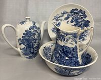 Full set showing the teapot, pitcher, bowl, and plate with blue and white scenic designs.