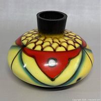 Front view of colorful hand painted glass vase with fish and geometric design, showing the wide round body and short neck.