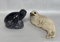 Black and white seal figurines shown side by side on a plain background.