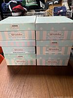 Stacked boxes showing the front sides including Madame Alexander brand and box design.