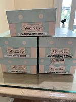 Stacked boxes showing all five Madame Alexander holiday doll model names