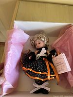 Madame Alexander Halloween Cat doll inside box showing doll in black dress with orange trim and accessories